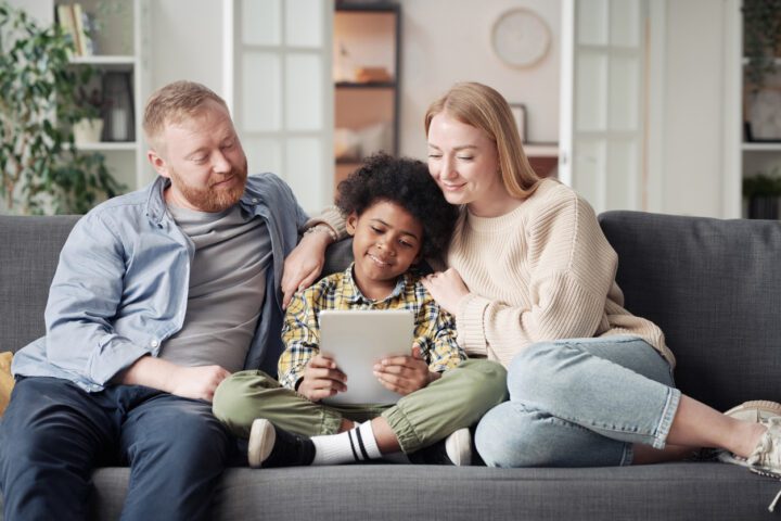 Happy child sitting with his foster parents