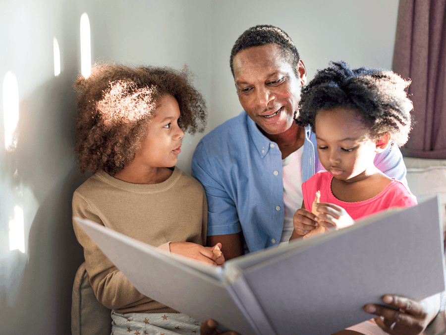 Dad reading to two young daughters