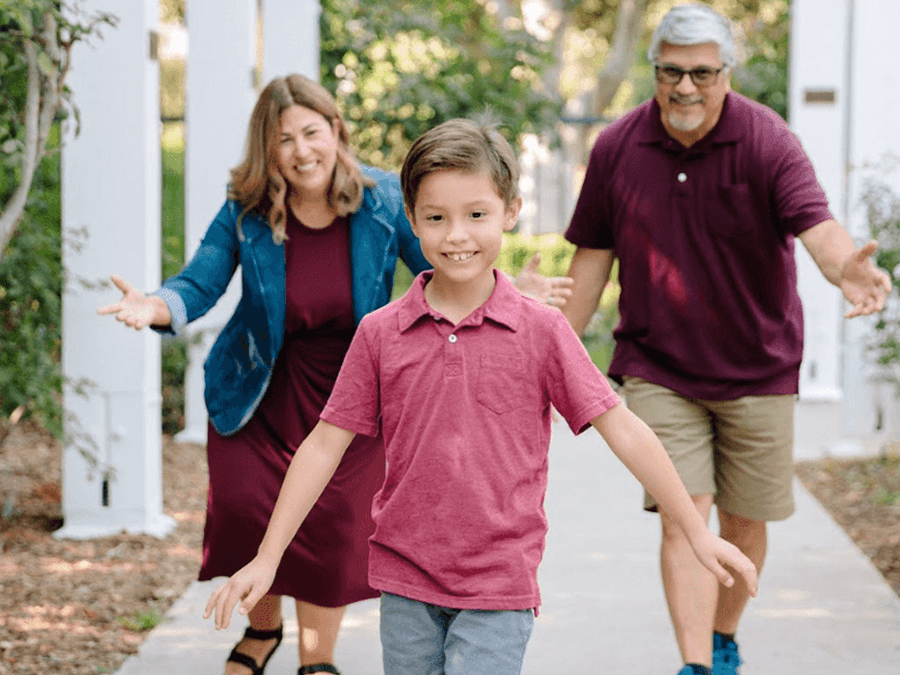Two grandparents running after a young child