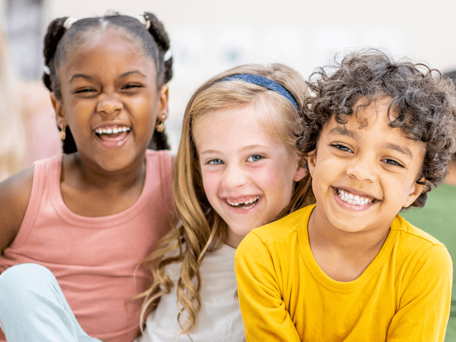 Three kids smiling at camera