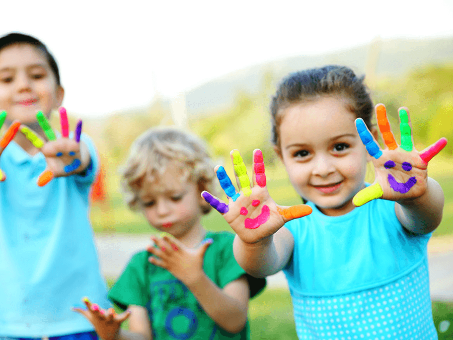 Kids showing off colorful finger paint on their hands